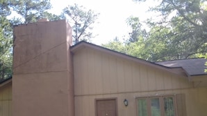 Une maison à deux étages avec un porche à l’avant et une porte.