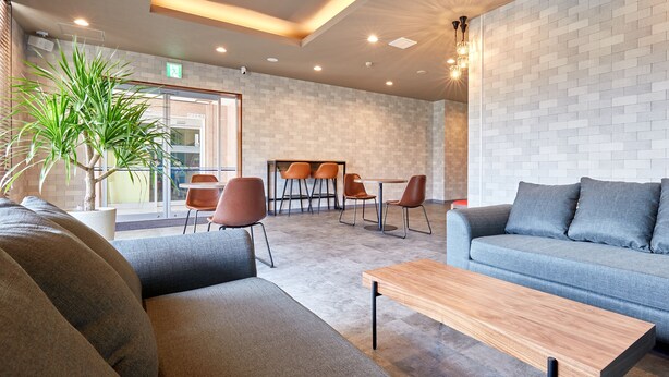 Un espace de détente moderne avec des canapés, une table basse et un mur décoré d’un motif en briques.