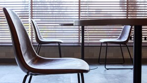 Un espace repas moderne avec une chaise à haut dossier et une table.