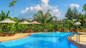 A swimming pool with lounge chairs and umbrellas, surrounded by tropical vegetation. - Villa Warin Khao Lak (Takua Pa)