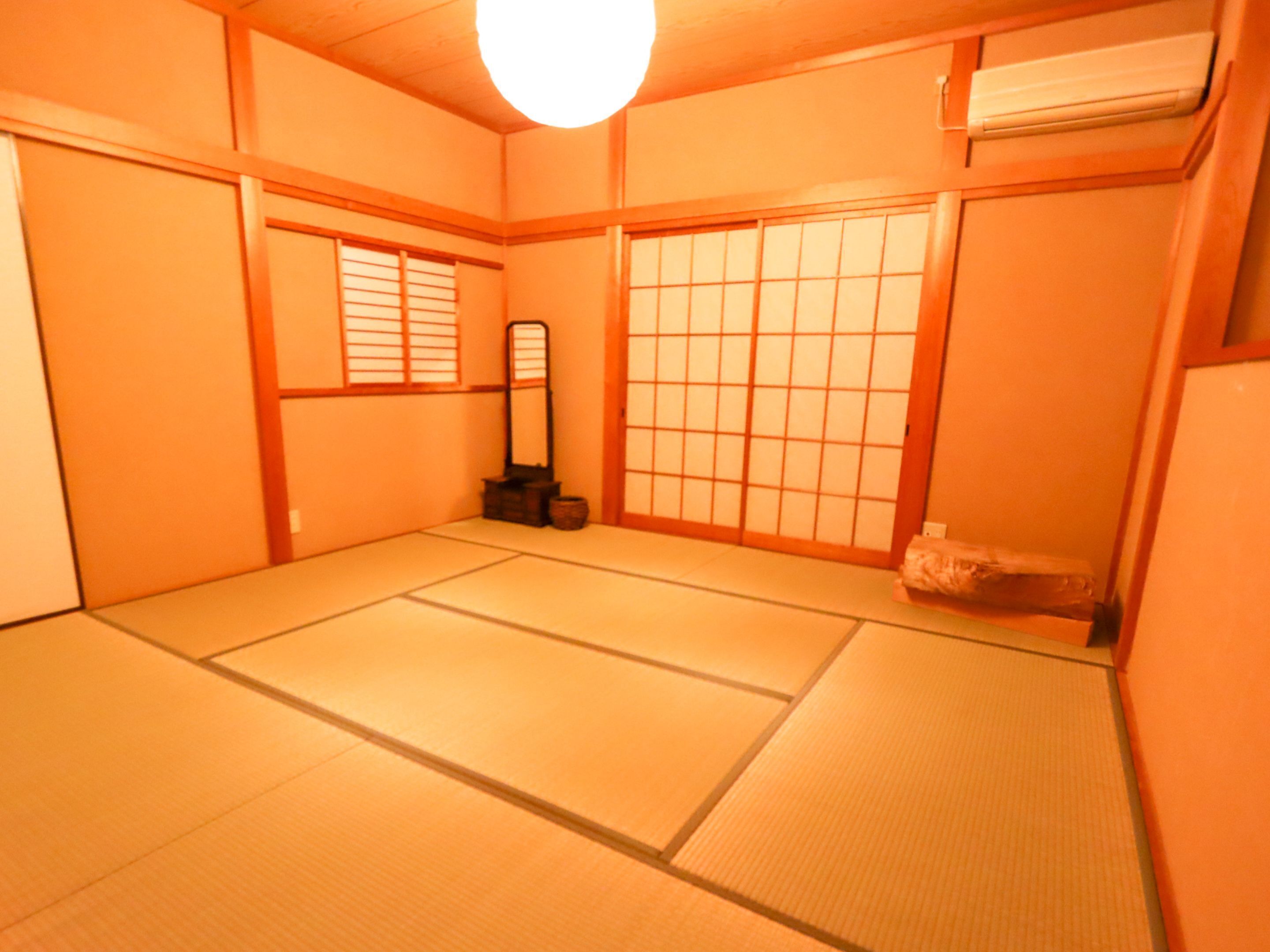 A traditional Japanese room with tatami flooring, sliding doors, and a shoji screen.