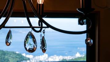 A chandelier with crystal decorations and a view of a cityscape through a window.