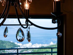 A chandelier with crystal decorations and a view of a cityscape through a window.