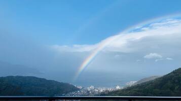 A cityscape with a rainbow over the hills.