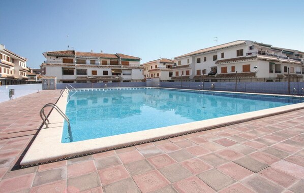 Relax by the pool surrounded by a low wall and access via a metal ladder.