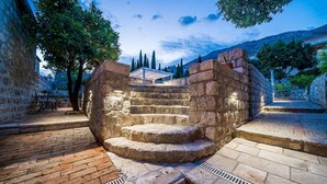 A stone staircase leading up to a covered area with a view of a mountainous landscape.