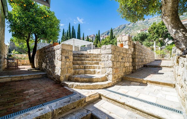 A stone staircase leading to a terrace with a view of a mountainous landscape. - Nice home in Donje Obuljeno (Donje Obuljeno)