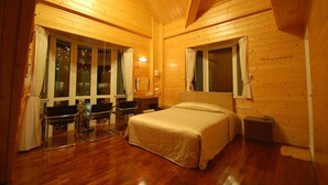 A wooden cabin room with a bed, two chairs, a desk, and large windows. - Cingjing Farm Jenku Villa (Ren'ai)
