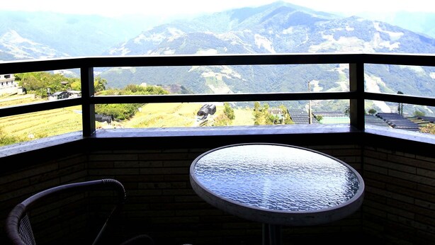 A room with a view of mountains, a round table, and a wicker chair. - Cingjing Farm Jenku Villa (Ren'ai)