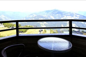 A room with a view of mountains, a round table, and a wicker chair. - Cingjing Farm Jenku Villa (Ren'ai)