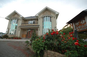 A two-story building with a prominent entrance and a balcony. - Cingjing Farm Jenku Villa (Ren'ai)