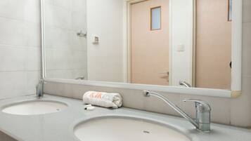 A bathroom with two sinks, a mirror, and a towel.