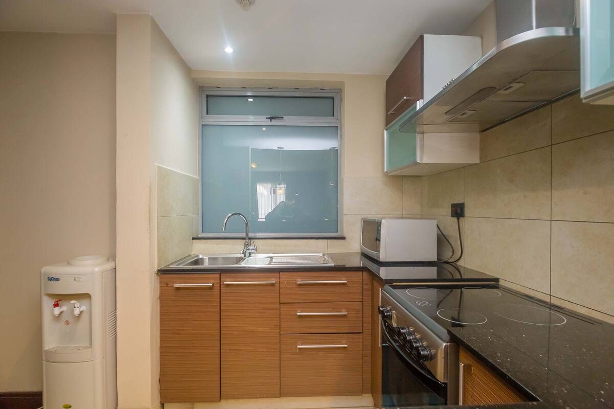 A compact kitchen with a built-in microwave, stove, and sink.