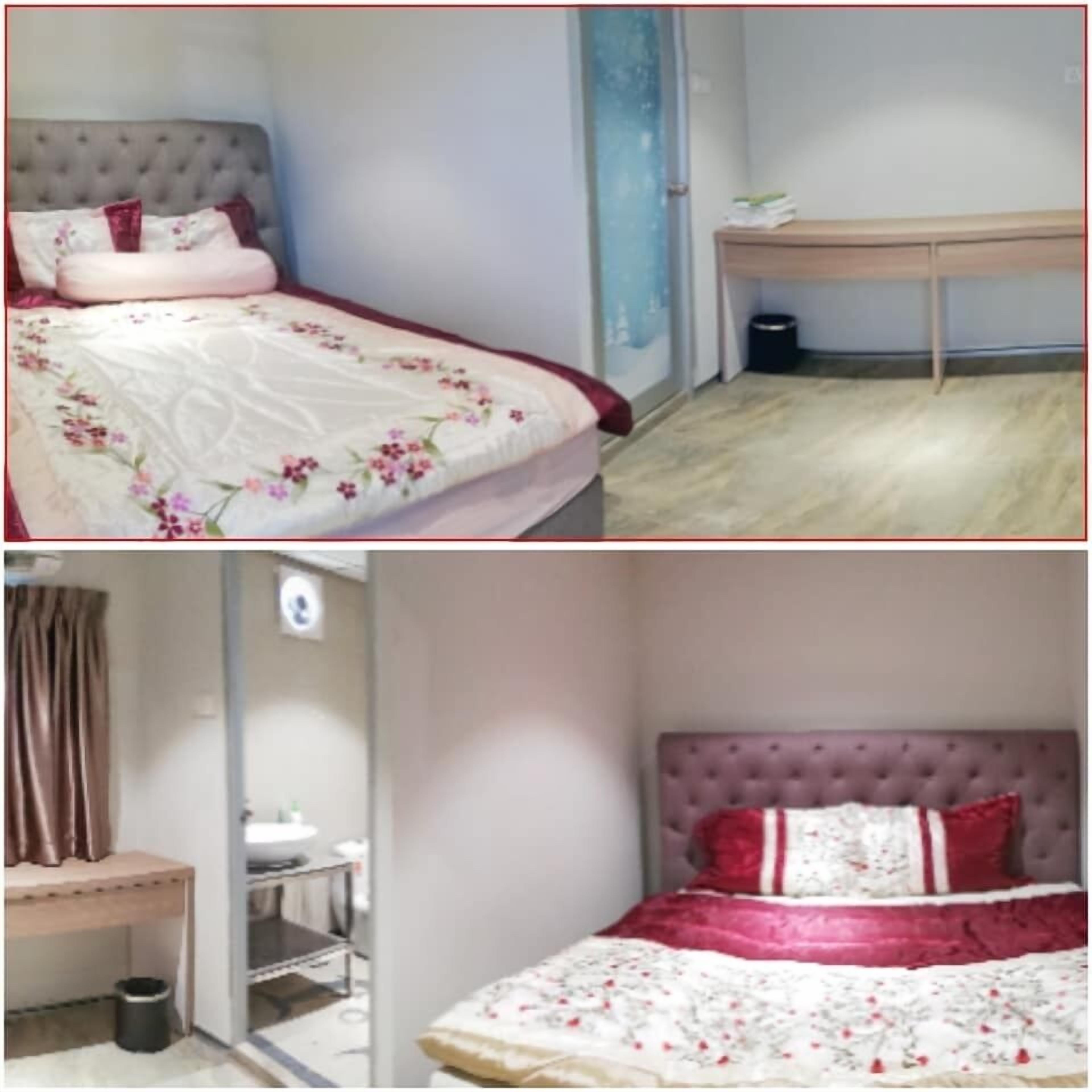 A bedroom with a bed, a desk, and a chair.