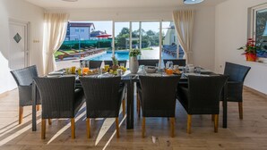 Un espace repas avec vue sur une piscine et un balcon.
