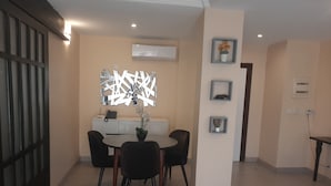 Un comedor con una mesa redonda, cuatro sillas y un espejo decorativo.