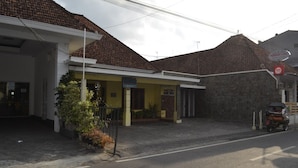 A building with a tiled roof and a signboard. - Prayogolama Guest House (Yogyakarta)
