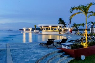 Una piscina al aire libre, sillones reclinables de piscina
