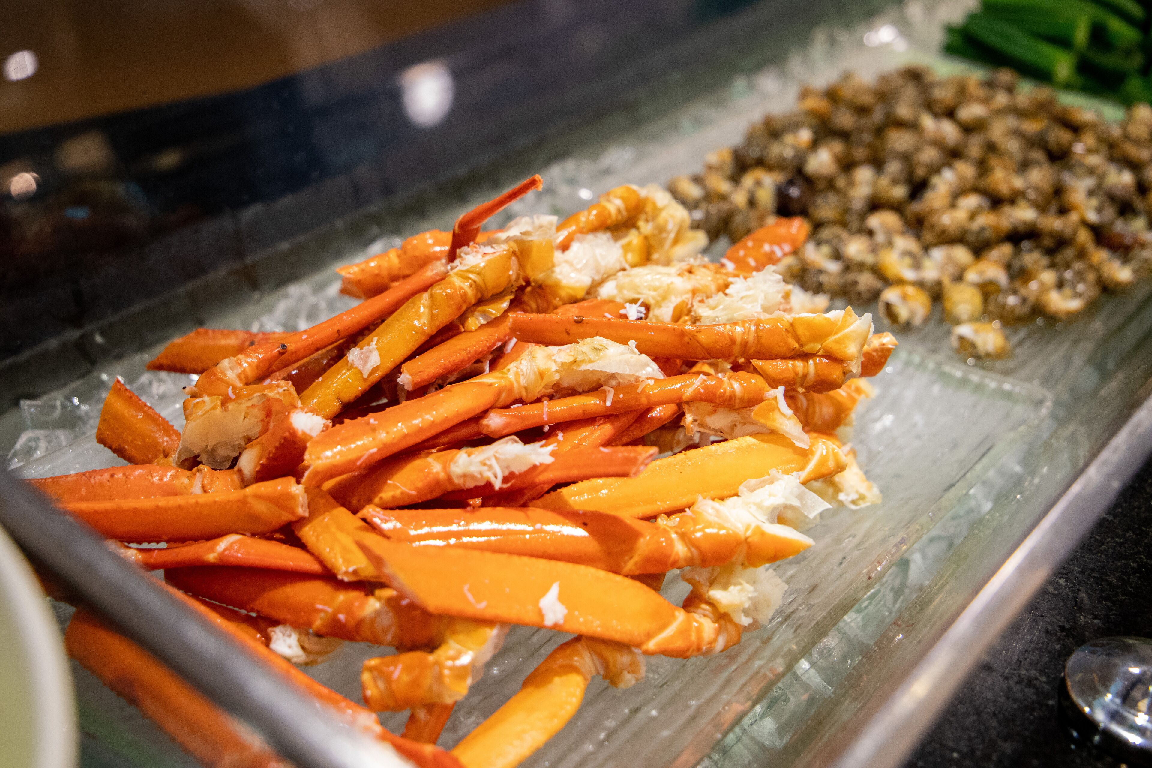 A seafood display with crab legs and shrimp on ice.