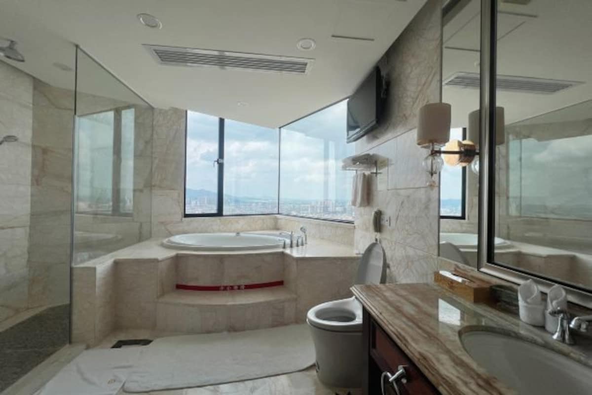 Un baño moderno con una bañera grande, zona de ducha separada y tocador con lavamanos.