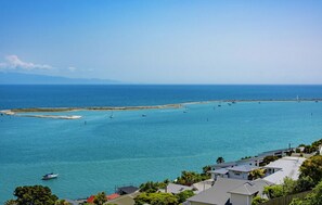 Une vue sur la côte, avec une eau bleue et limpide, une plage de sable et plusieurs bateaux.