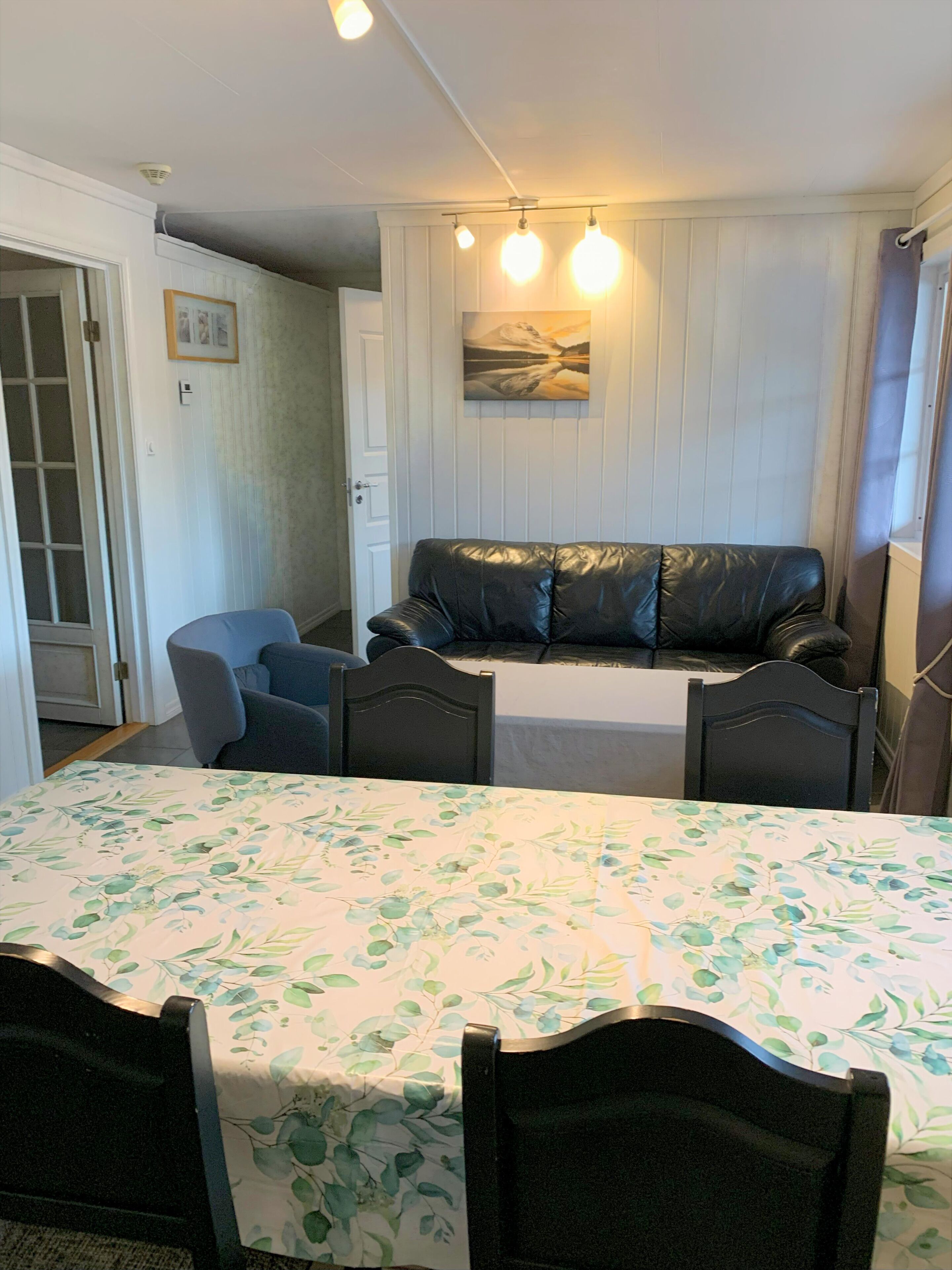 Um quarto com cama, sofá, mesa de jantar com cadeiras e um quadro na parede.