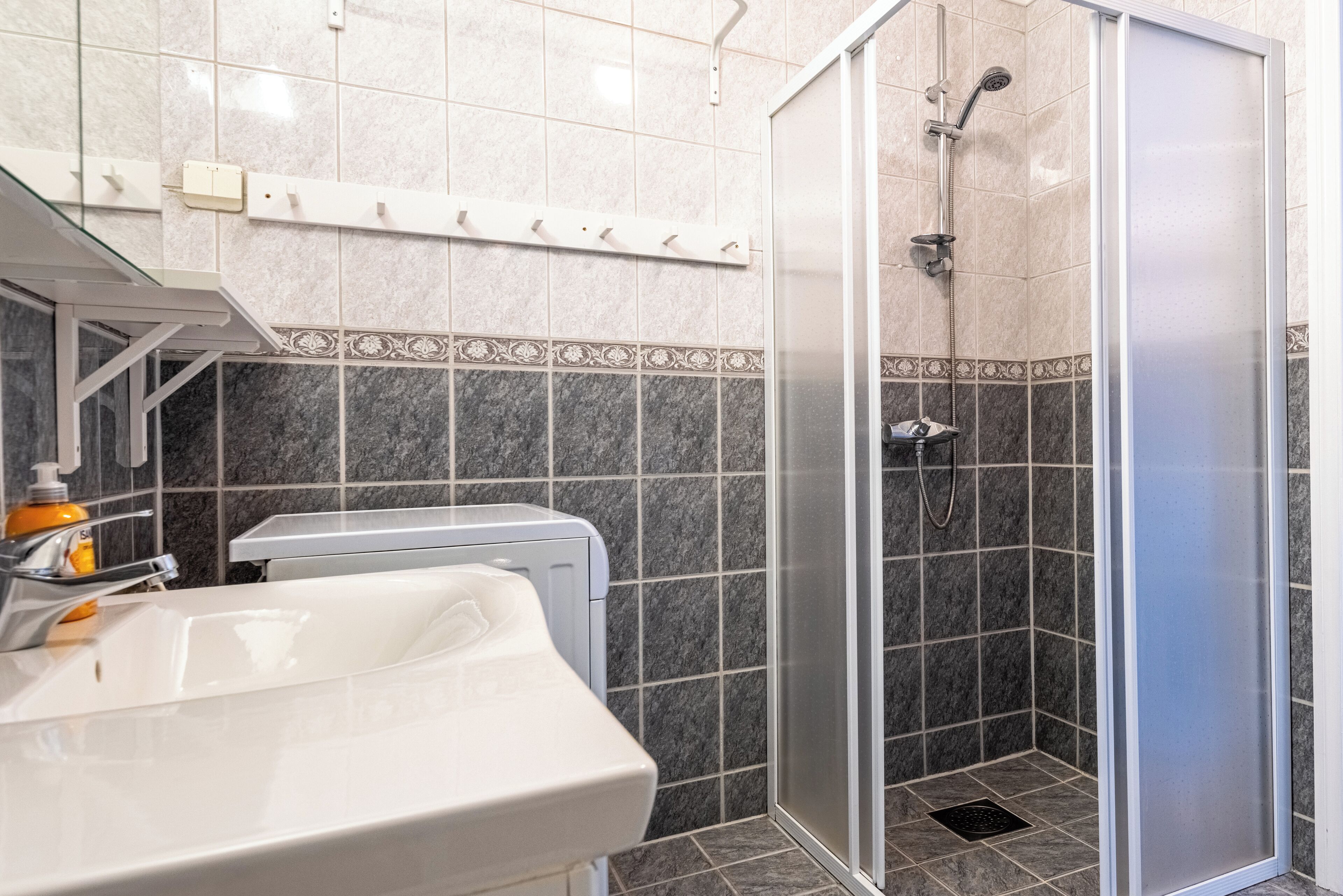 A bathroom with a shower, a sink, and a toilet.