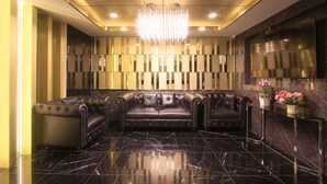A luxurious lobby with a black leather sofa, a reflective floor, and a modern chandelier. - Pratunam Atrium Hotel (Bangkok)