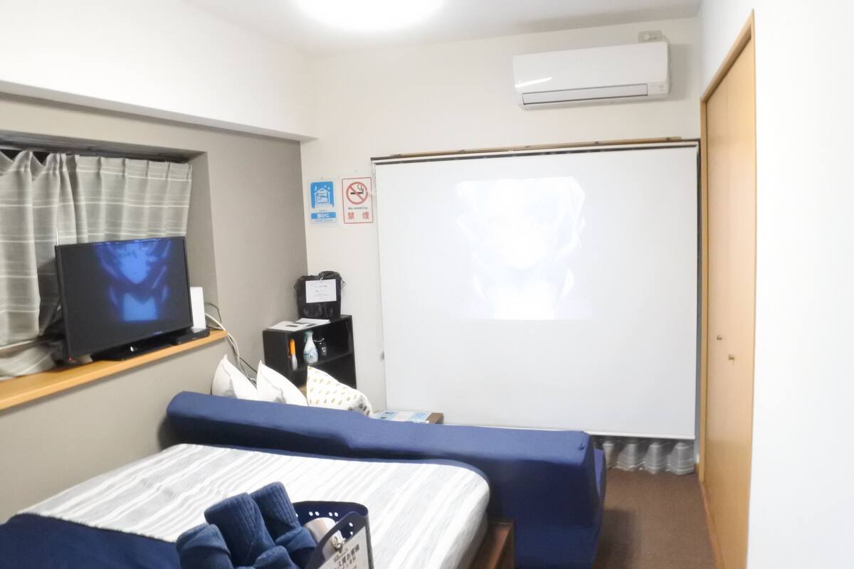 A hotel room with a bed, a television, a desk, and a whiteboard.
