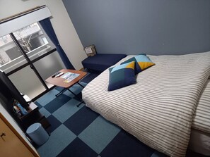 A compact hotel room with a bed, a small desk, and a window. - Cross Stage (Fukuoka)