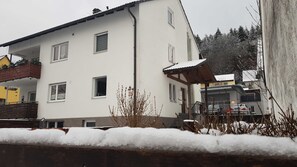 A two-story building with a white facade, multiple windows, and a covered outdoor area. - Vacation apartment Schwarz (Ebermannstadt)