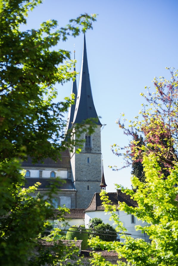 A church with a tall spire and a white building with arched windows.