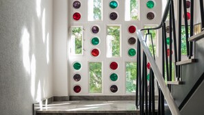 A staircase with a railing and a wall with circular windows. - Appartements Hofquartier (Lucerne)