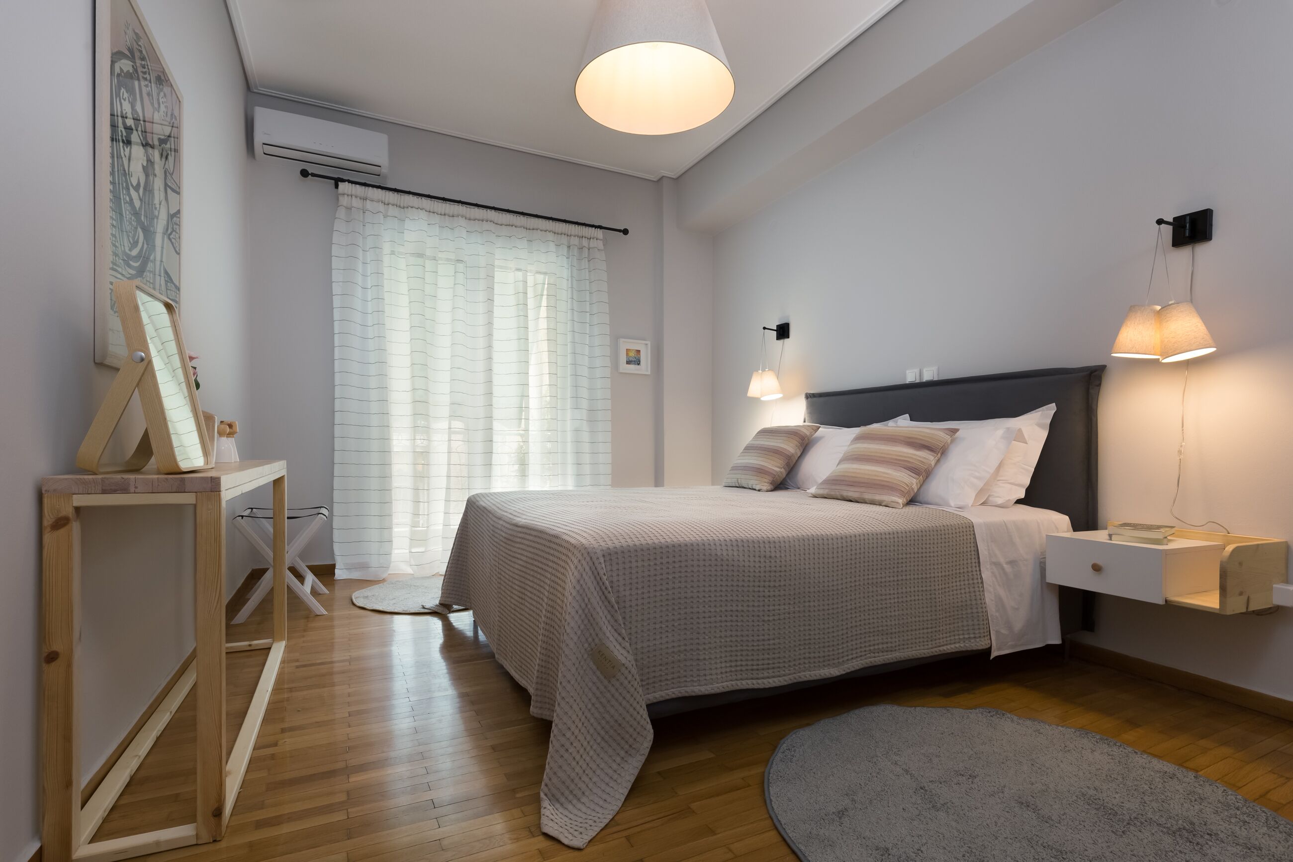 Une chambre à coucher avec un lit, une table de chevet, une lampe et un tableau au mur.