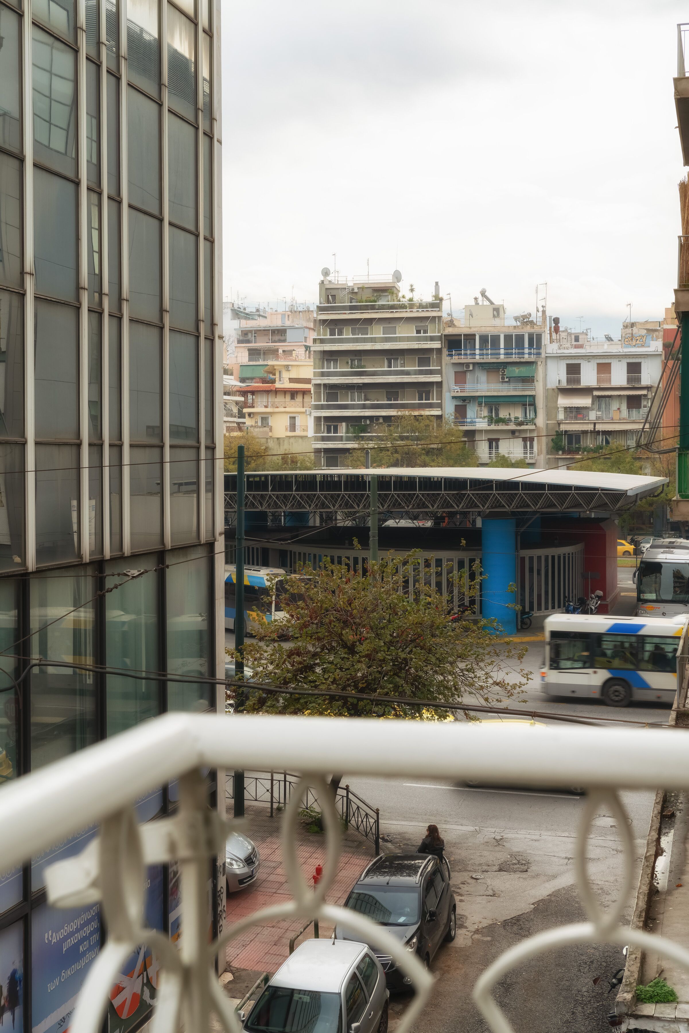 Blick auf ein modernes Gebäude mit großen Fenstern und einem Parkplatz davor.