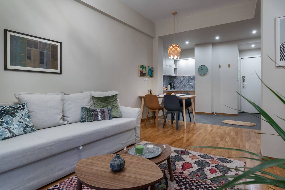Un salon moderne comprenant un canapé, une table basse et un coin repas avec des chaises et une table.