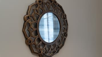 A wall-mounted mirror with an ornate, geometric frame.