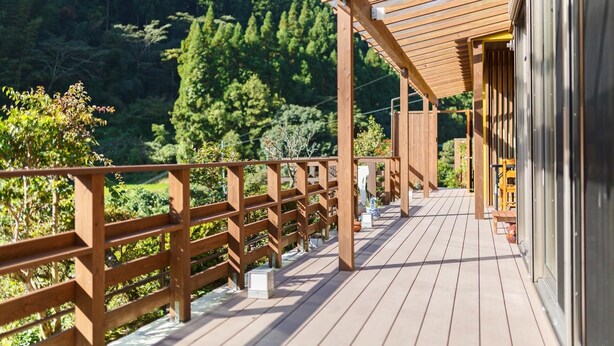 A wooden deck with a railing, leading to a building with glass doors. - Ukiha Kojio no Akari (Ukiha)