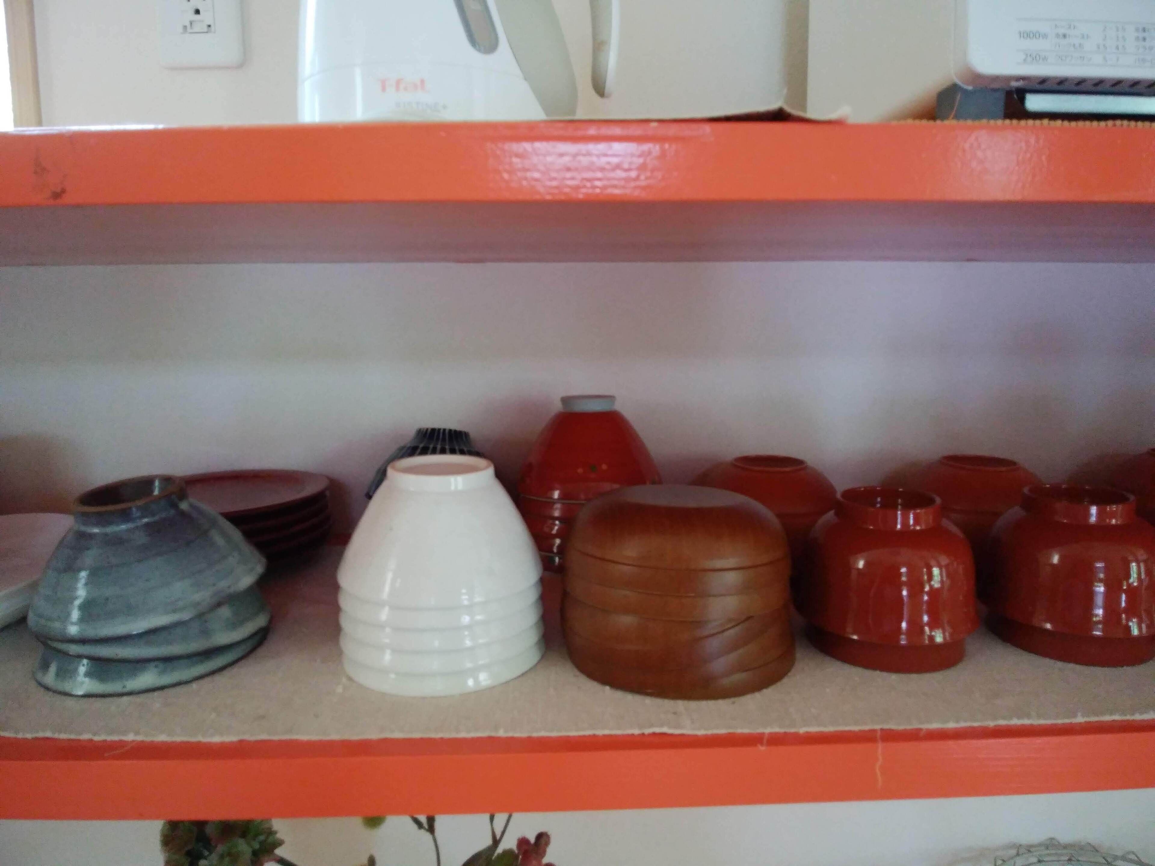 Una estantería con varios recipientes de cerámica.