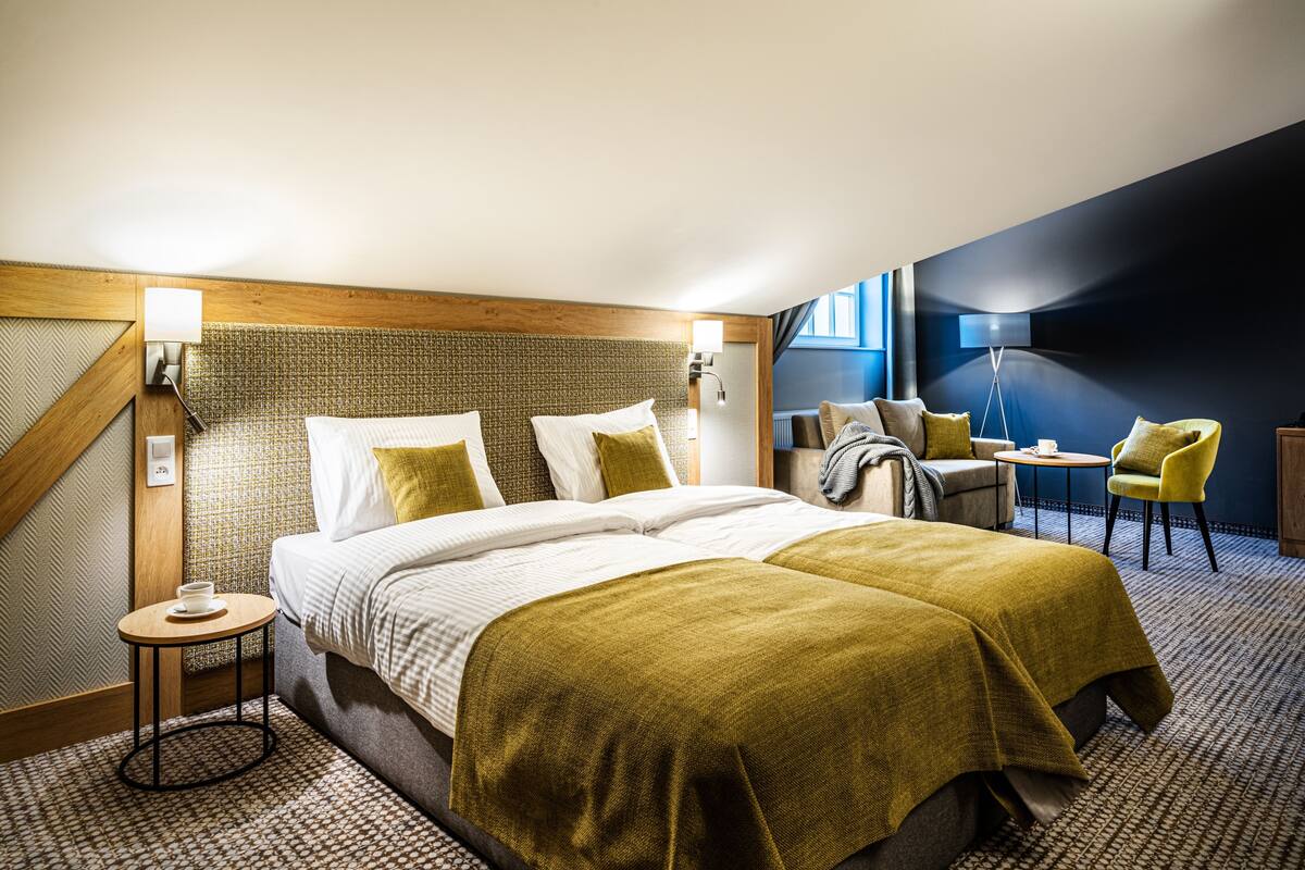 Une chambre d’hôtel avec un grand lit, une petite table ronde, une chaise et un bureau.