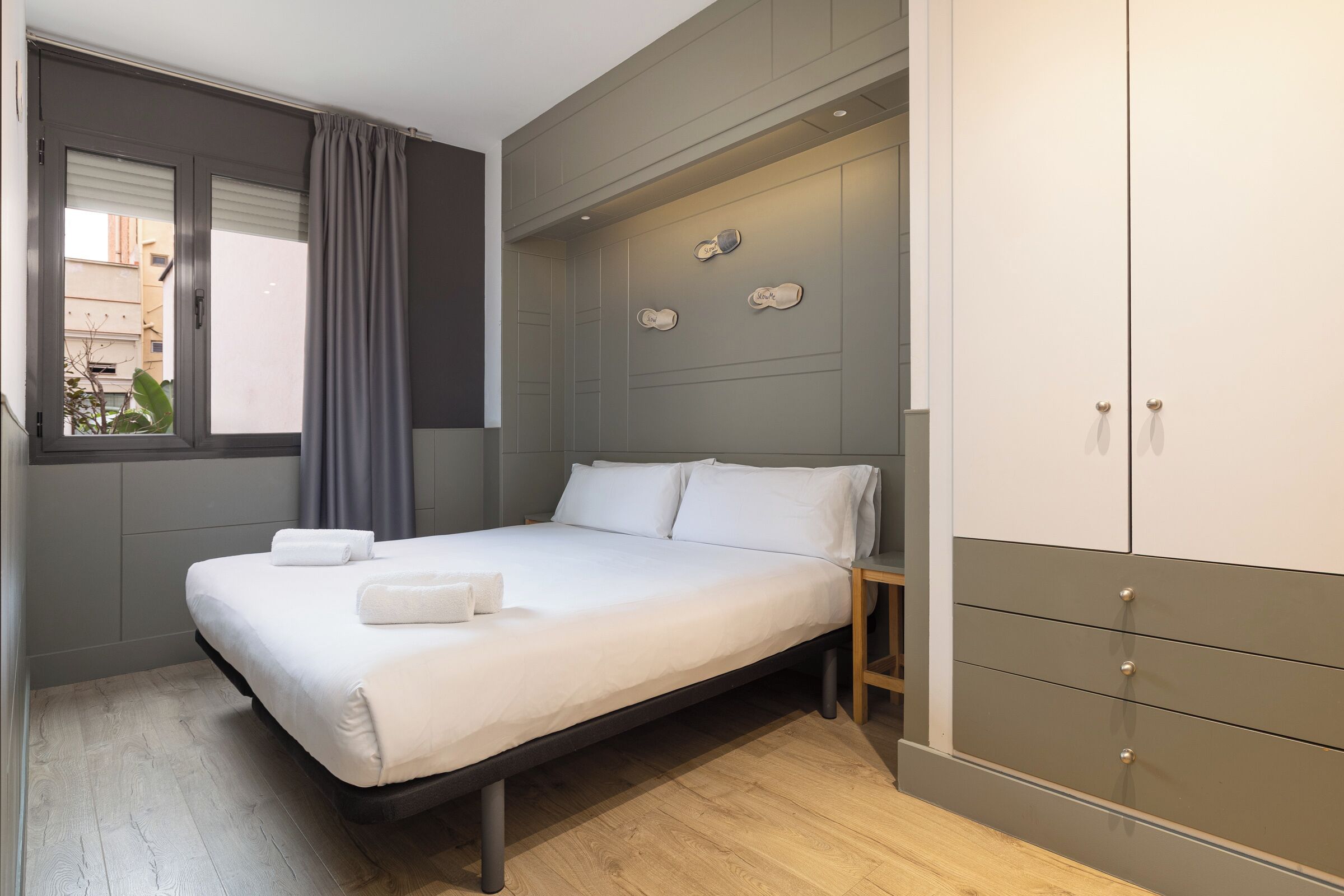 Une chambre à coucher avec un lit, une armoire et une fenêtre avec des rideaux.