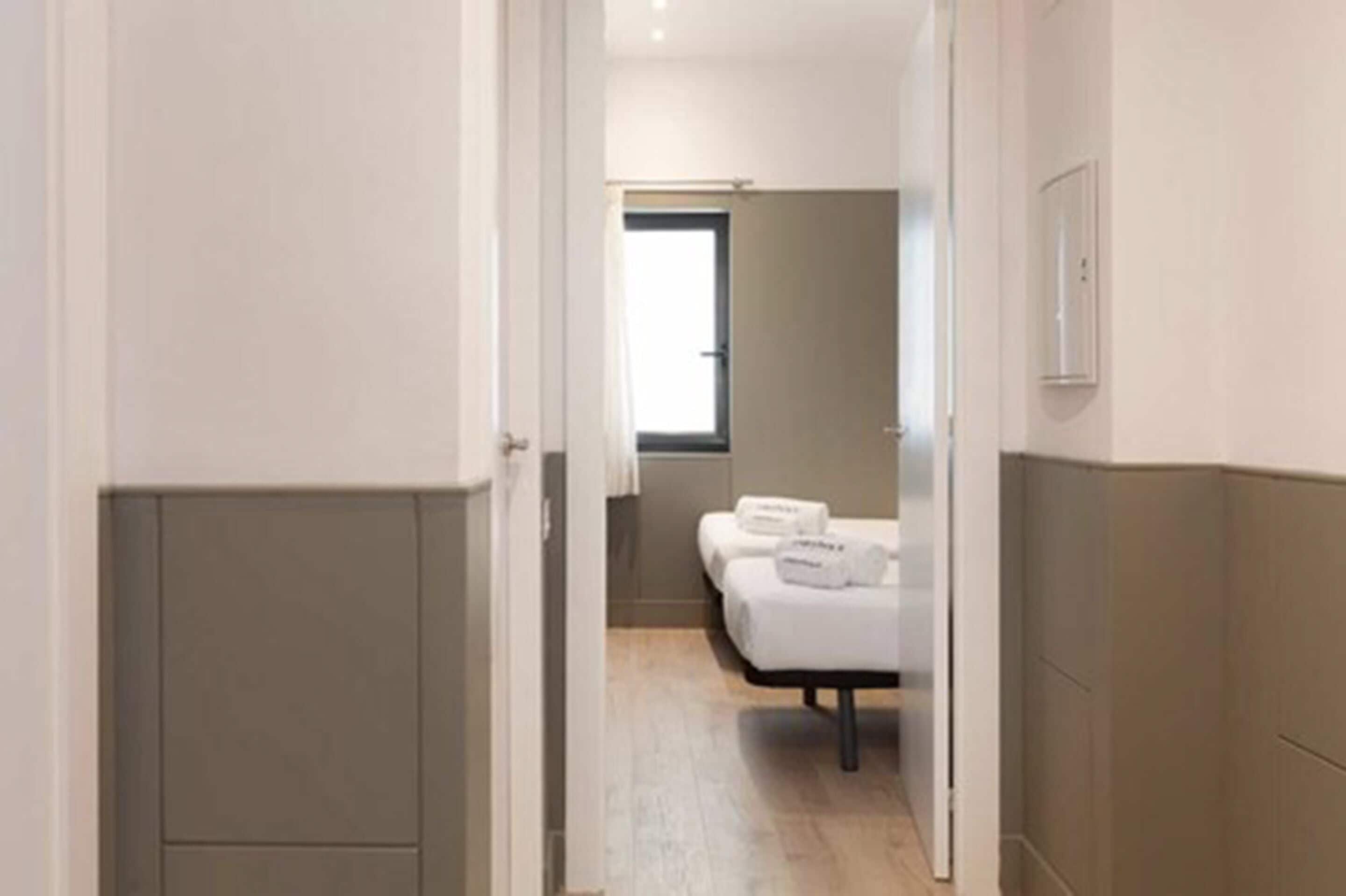 Ein Hotelzimmer mit Bett, Fenster und Tür.