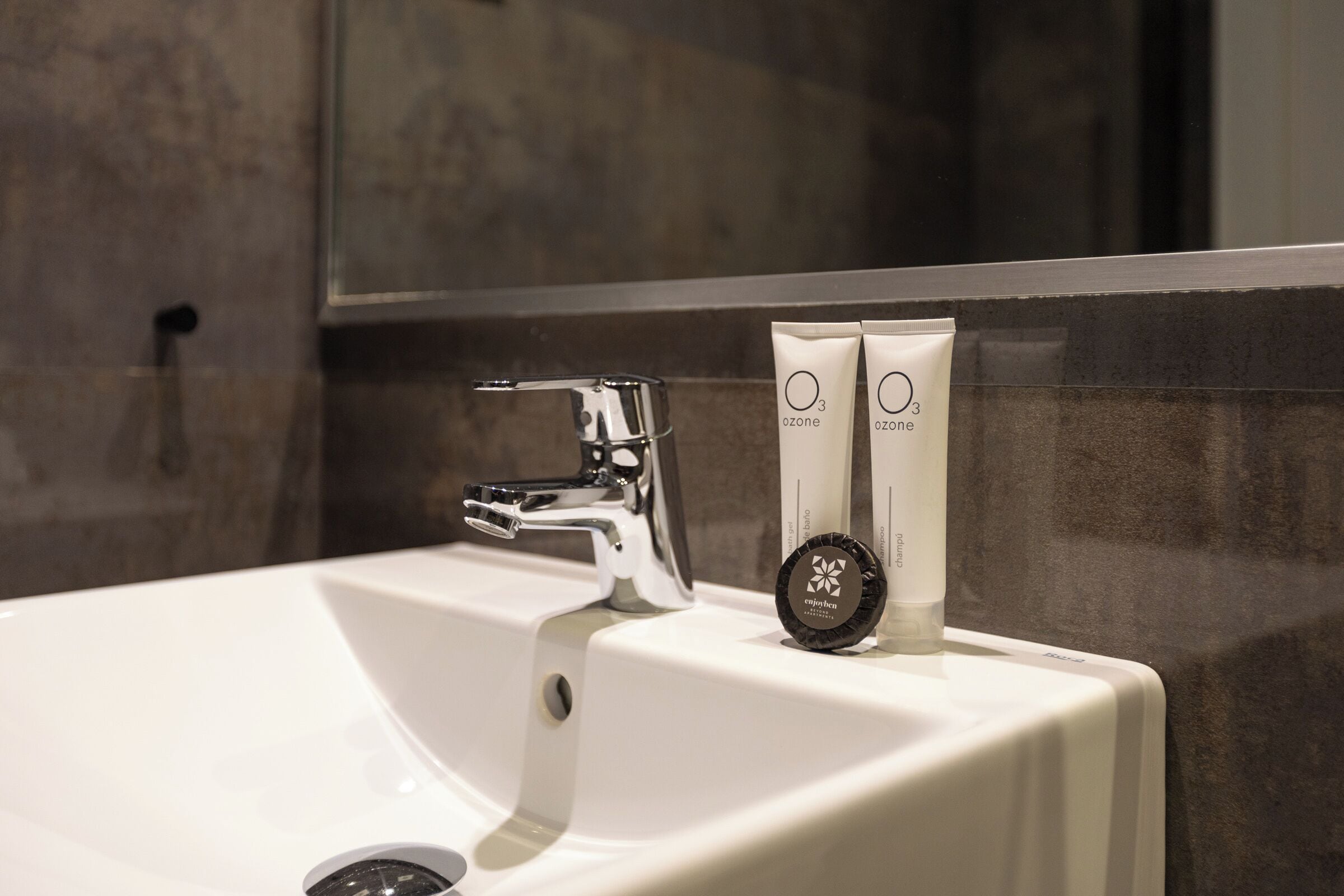 A bathroom sink with a chrome faucet and two tubes labeled "ozone" on the counter.