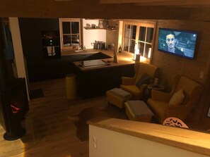 Kodikas olohuone, jossa on sohva, sohvapöytä ja seinälle asennettu televisio.