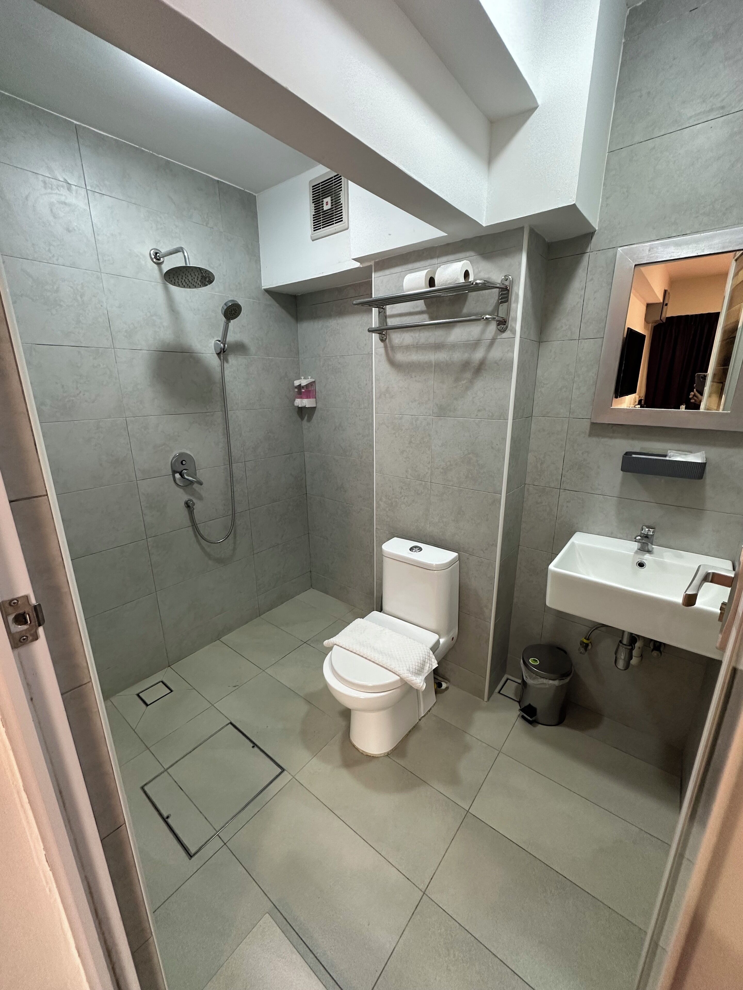 Une salle de bain moderne équipée de toilettes, d’une douche et d’un lavabo.
