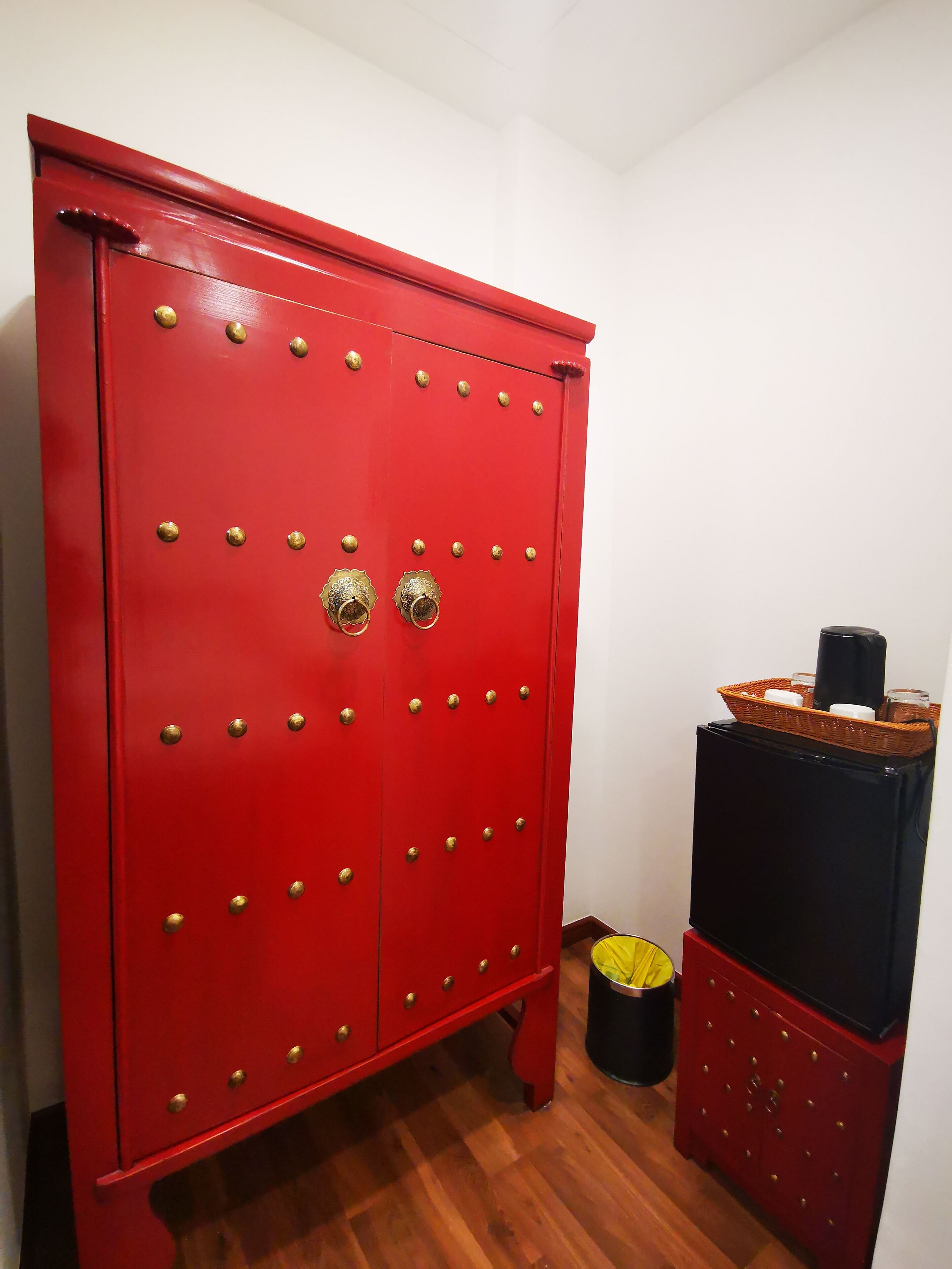 A red metal cabinet with multiple drawers and brass handles.