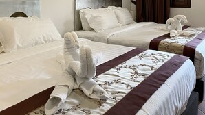 A hotel room with two beds, each with white linens and decorative pillows. There is a painting on the wall and a window with curtains. - Mclane Boutique Hotel (George Town)