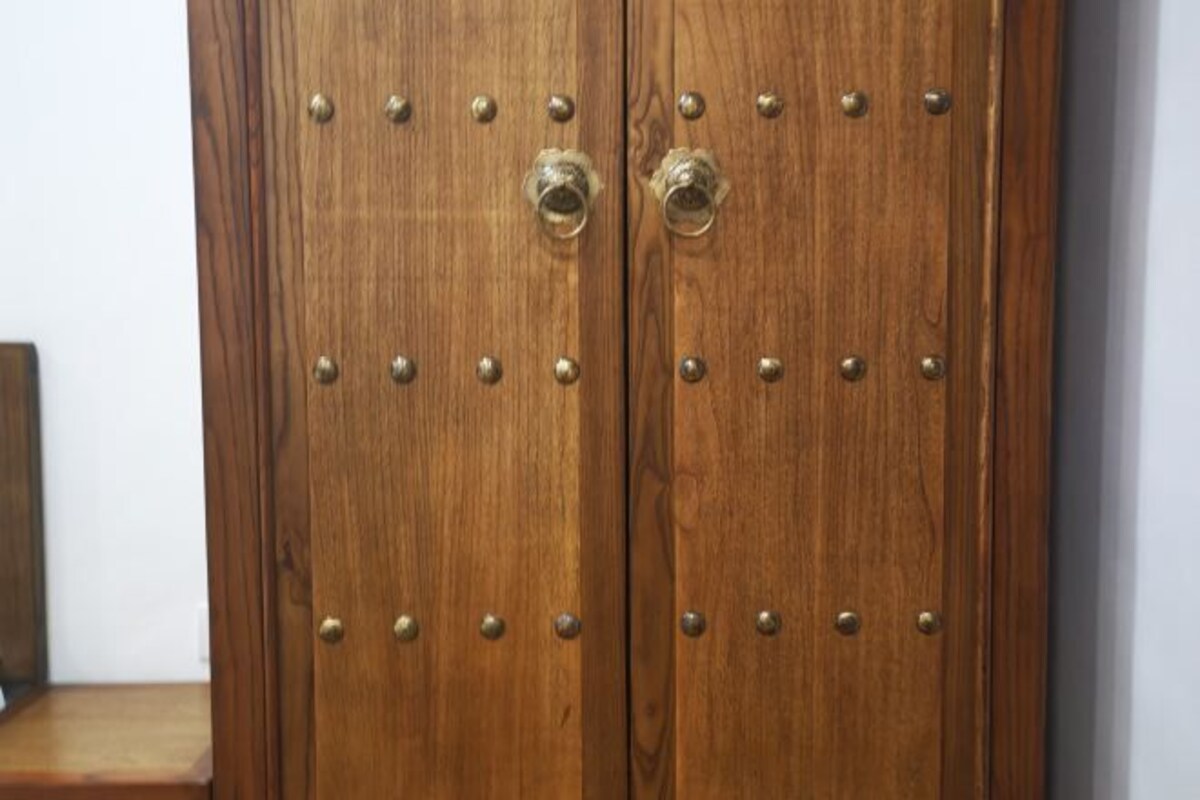 A wooden double door with metal studs and two round handles.