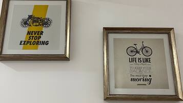 Two framed motivational posters, a wall-mounted security camera, and directional signs.