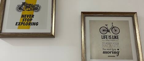 Two framed motivational posters, a wall-mounted security camera, and directional signs.